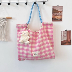 Pink checkered woven tote bag with blue floral drawstring straps and white sheep pendant