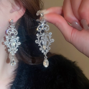 Detailed view of silver-tone tassel earrings with sparkling rhinestones and teardrop crystals