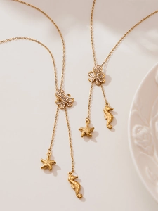 Détail du pendentif pieuvre dorée avec zircons et pampille étoile de mer sur collier en Y