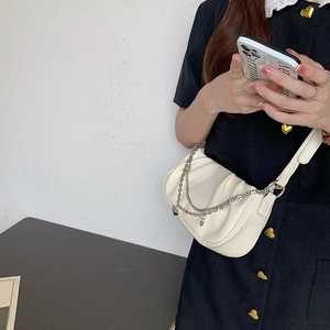 White cloud-shaped pleated shoulder bag detail with silver chain strap on model
