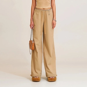 Detail of khaki wide-leg pants featuring cross embroidery and adjustable drawstring hem