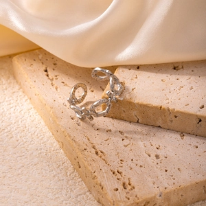Irregular hammered silver-toned open link ring on a minimalist stone display