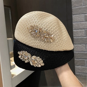 Detailed close-up of woven beret fabric with crystal leaf side embellishment