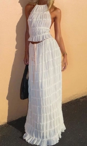 Detail of white pleated halter top and high-waist maxi skirt set with chiffon texture