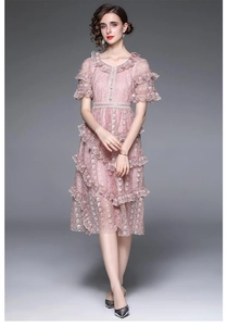 Détail de robe d'été en dentelle rose avec col en V à volants et broderie fine