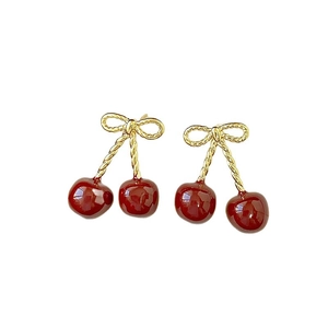Elegant cherry stud earrings with golden bows and deep red resin spheres on a white base