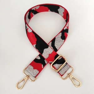Detail of adjustable camo shoulder strap with red black silver weave and gold hardware