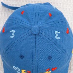 Detailed macro view of a blue baby baseball cap crown with heart and letter embroidery