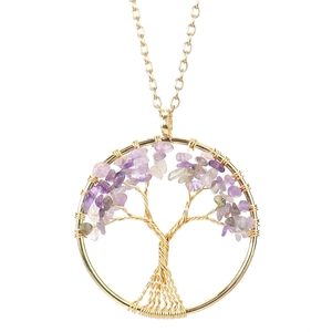 Detailed view of handmade gold wire-wrapped tree of life pendant with purple crystals