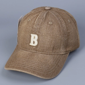 Close-up of vintage brown cotton baseball cap featuring textured letter B embroidery