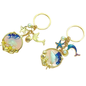 Ocean theme keychain with dolphin, starfish, and shells in blue gradient resin pendant