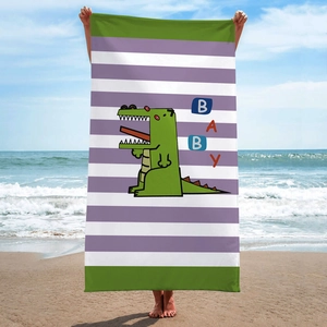 Detailed view of microfiber beach towel with purple stripes and a cartoon crocodile design
