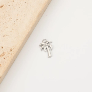Macro shot of silver coconut tree pendant with polished surface and hanging loop