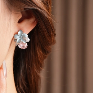 Gros plan sur boucle d'oreille vintage fleur bleue claire et goutte en cristal rose