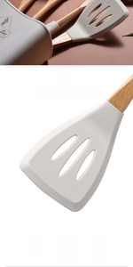 Detail of slotted silicone spatula with wooden handle showing heat resistance and storage bucket
