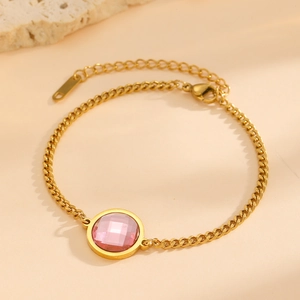 Detailed close-up of 18K gold plated chain bracelet with a faceted round pink gemstone
