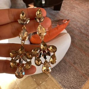 Detailed view of amber teardrop crystal tassel earrings with gold-toned setting