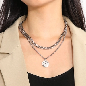 Detail of silver double-layered necklace featuring a zodiac pendant on a chunky curb chain