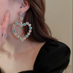 Gros plan de boucles d'oreilles cœur de luxe avec strass colorés sur un mannequin femme