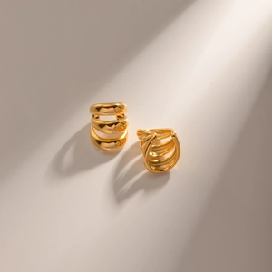 Macro shot of polished triple-layered 18K gold stainless steel minimalist ear cuffs
