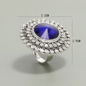 Detailed view of a silver cocktail ring with a large blue stone and diamond accents