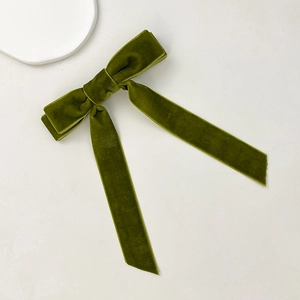 Detail of olive green velvet bow hair clip with elegant long ribbon streamers