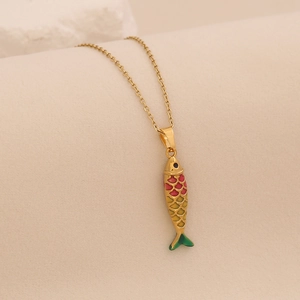 Detail of a colorful fish pendant necklace with vibrant enamel scales and gold chain