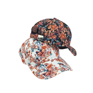 Close-up detail of floral baseball caps with curved brims and metal adjustment buckles