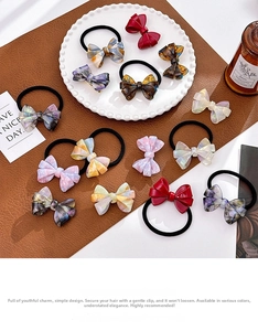 Dettaglio di fermagli per capelli a fiocco tartarugati ed elastici per capelli colorati