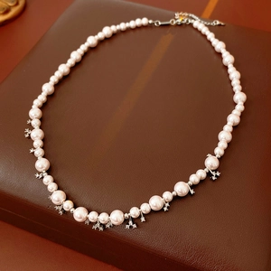 Detailed view of zircon pearl beaded necklace with silver floral accents on leather base