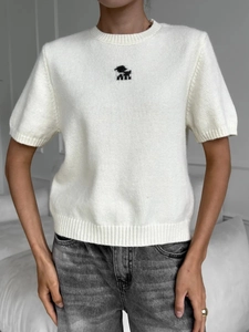Dettaglio maglietta bianca in maglia slim con motivo animale pixelato sul petto