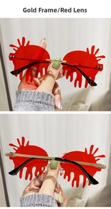 Detail view of teardrop frameless sunglasses with red lenses and gold metal temples