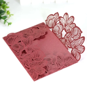 Detailed laser-cut floral pattern on burgundy red pearlescent paper invitation cover