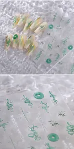 Macro view of green bamboo and snake motif nail decals with artistic calligraphy details