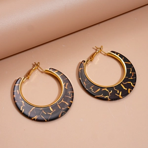Retro geometric resin hoop earrings with gold foil texture on a warm matte surface