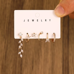 Detailed view of 6-piece gold ear piercing set with butterfly and zircon accents