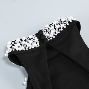 Detail of elegant black neckline featuring handcrafted white pearls and silver rhinestones