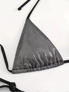Dettaglio del top bikini allacciato al collo nero con decorazioni in strass argentati