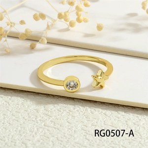 Detail of gold open ring featuring star motif and clear cubic zirconia on textured background