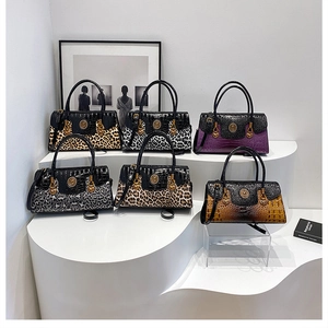 Detail of high-end ladies handbags featuring golden lion head logo and animal print textures