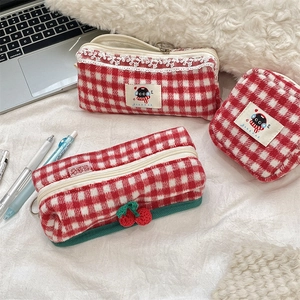 Detailed macro view of red plaid wool stationery pouch with cute cat embroidery and cherry charm