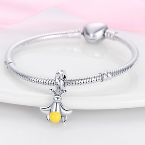 Silver snake chain bracelet featuring a delicate yellow firefly charm on white surface