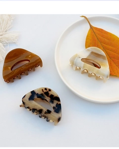 Flat lay of acetate hair claws in dark amber, marble white and tortoiseshell patterns