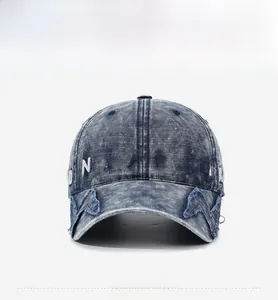 Close-up of vintage blue washed denim baseball cap with white 3D letter embroidery