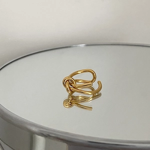 Close-up of golden irregular metal knot ring with creative minimalist line design
