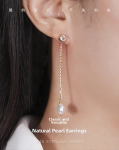 Detail of s925 silver long drop earring featuring a natural freshwater pearl and zircon