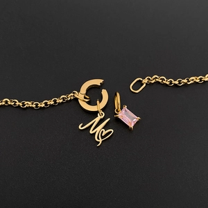 Detail view of 14K gold plated stainless steel bracelet with letter M heart and pink stone