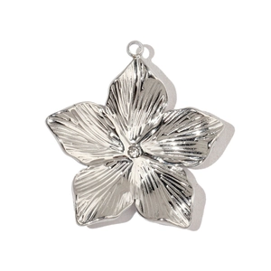 Close-up of a silver five-petal flower pendant with textured petals and a zircon center