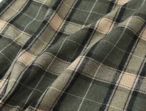 Gros plan sur un tissu en flanelle à carreaux vert foncé aux fibres texturées