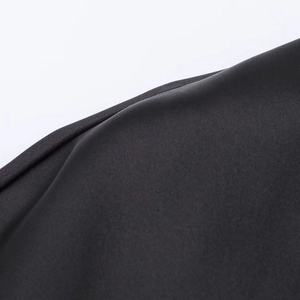 Close-up of black satin dress fabric showing smooth texture and fine twill weave detail